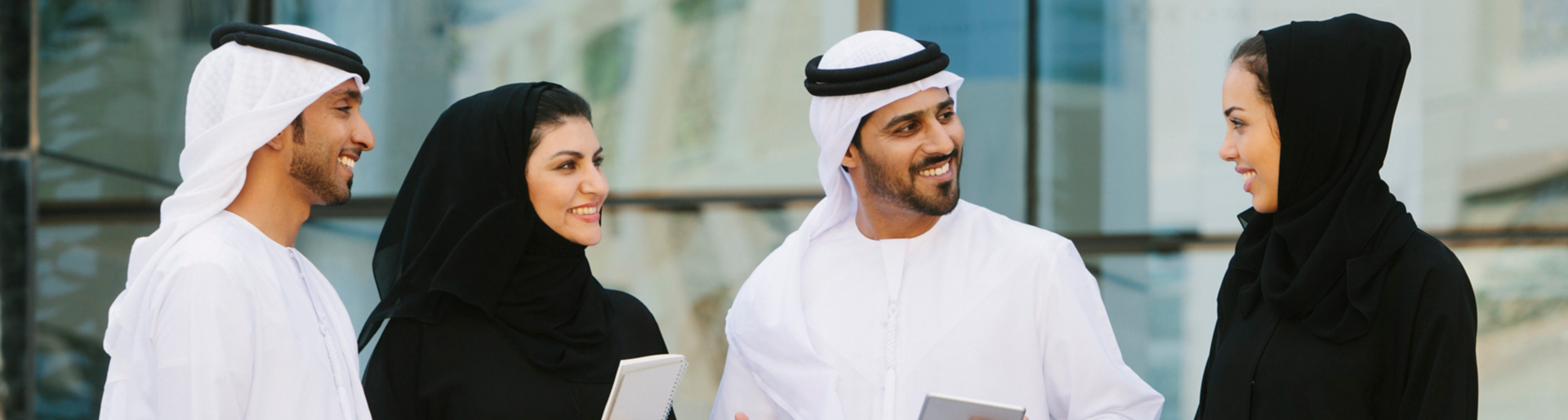 Four arab businesspeople in traditional clothing having a discussion in front of a  office building.