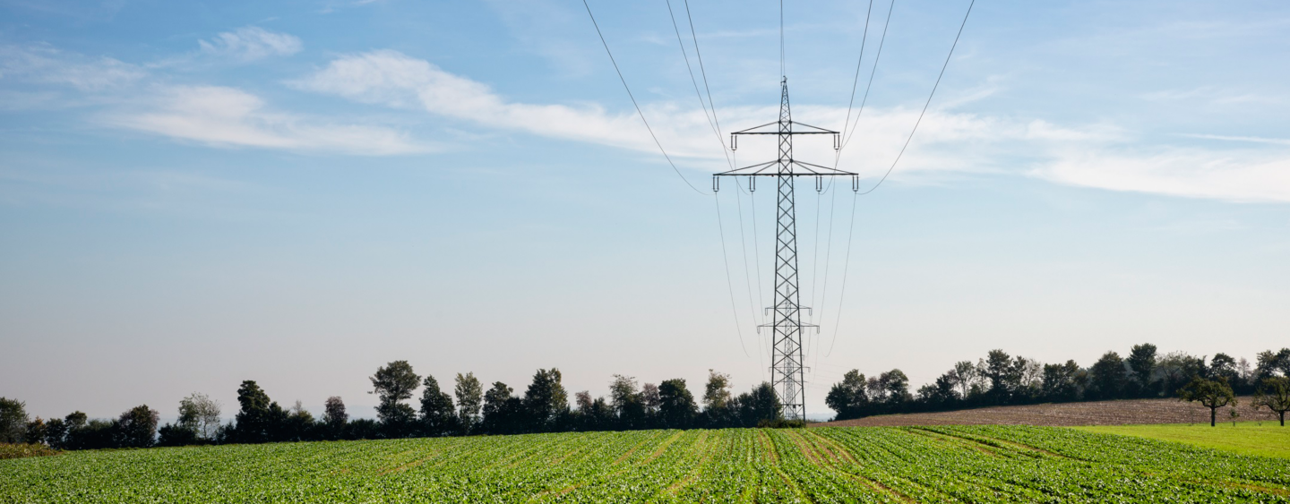 Transmission towers and power lines in agricultural fields.