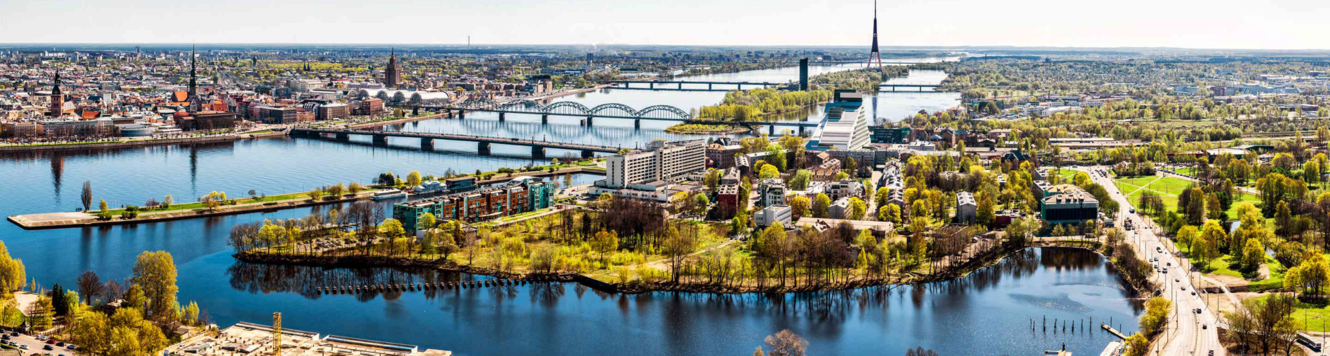 Panoramic aerial image horizontal photo of Riga cityscape centre capital of Latvia, Daugava river sunny spring day, banner for website header design, copy space. European city, horizon over land