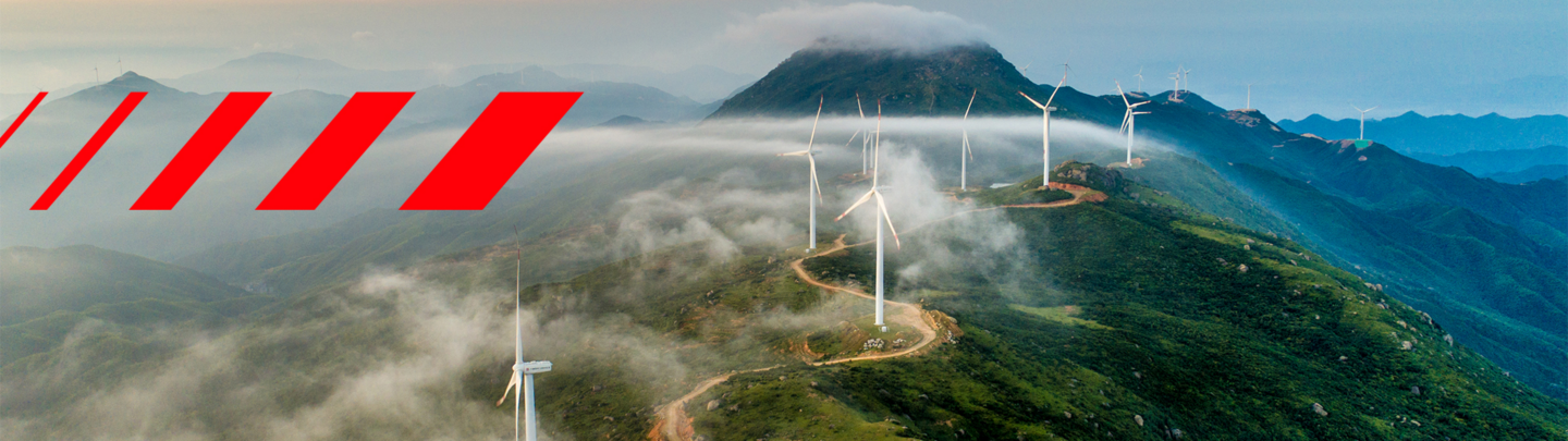 Hitachi Energy signature red pattern on mountain with wind turbines