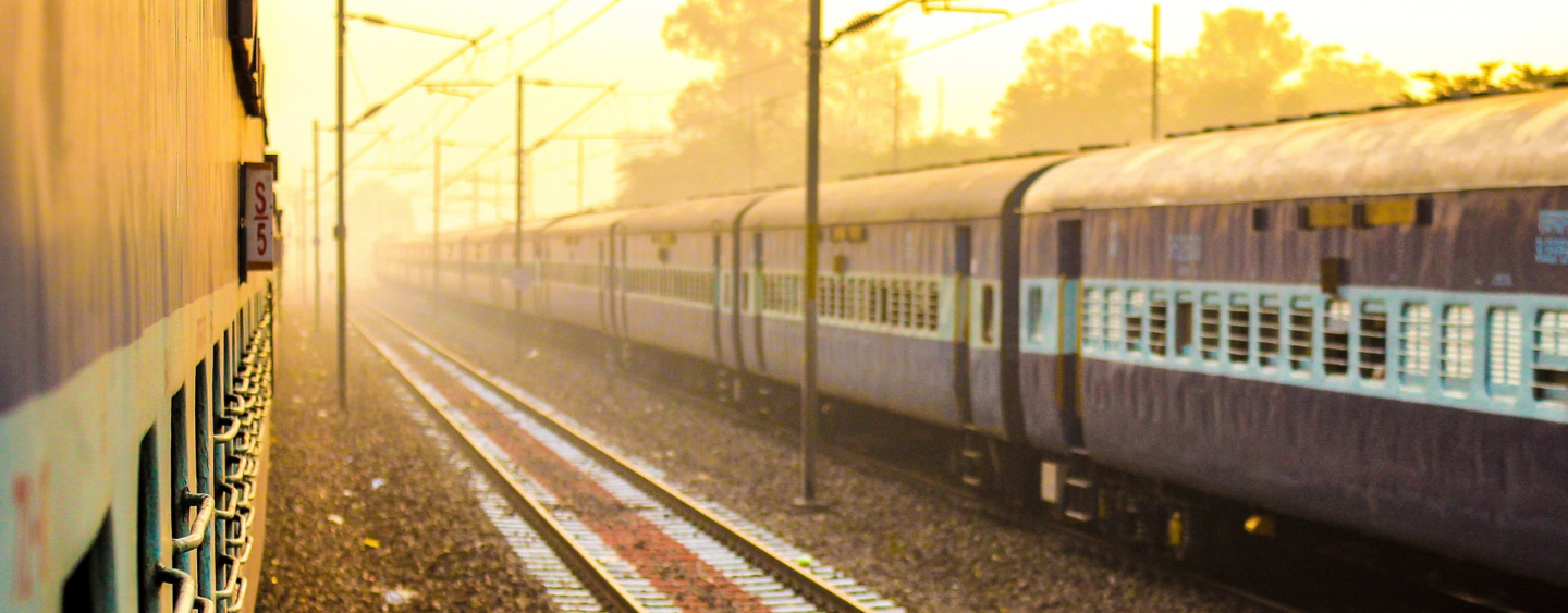 beautiful morning image of two Indian train with rail between them in yellowish morning light and a bit fogg. Perfect to show Indian railways system in news or article