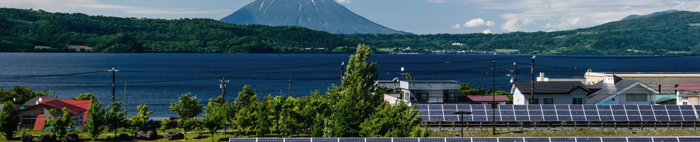 Solar cell panel and village in rural area with mountain landscape background